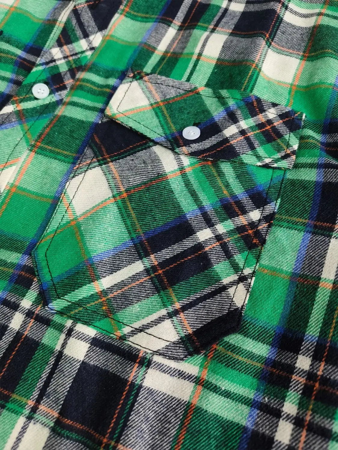 Men’s slim fit plaid flannel button up shirt in green black and white with a chest pocket secured by two light blue buttons.