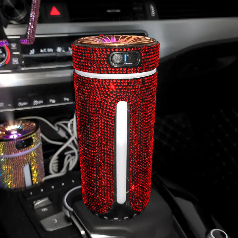 Ein mit roten Strasssteinen besetzter Autoluftauffrischer mit einer goldfarbenen Oberseite und einem weißen vertikalen Akzentstreifen für den Diamant-Auto-Befeuchter-LED-Strass-USB-Luftdiffusor.