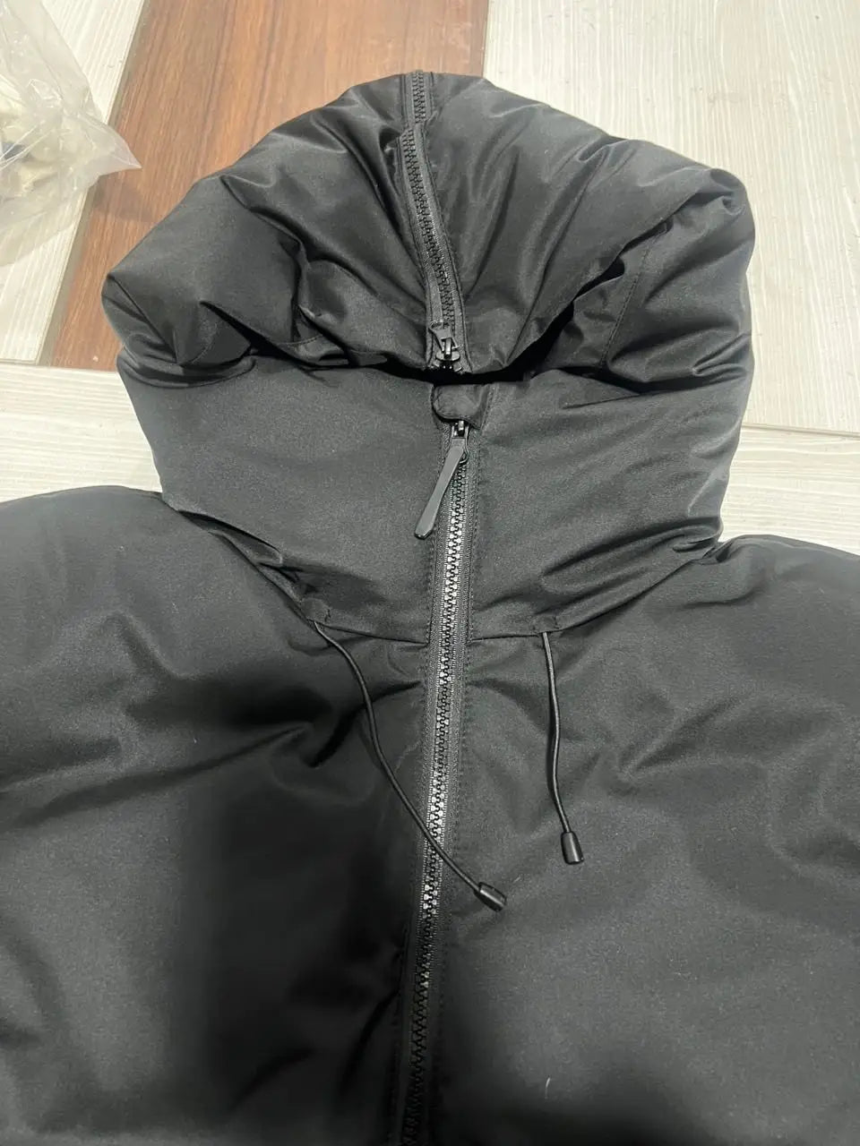 Black women’s belted hooded puffer coat with zipper closure and drawstrings designed for warmth and style