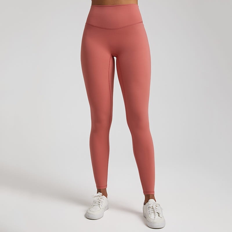 A pair of high waisted stretch fitted leggings in pink made from stretchy athletic fabric designed for active wear.