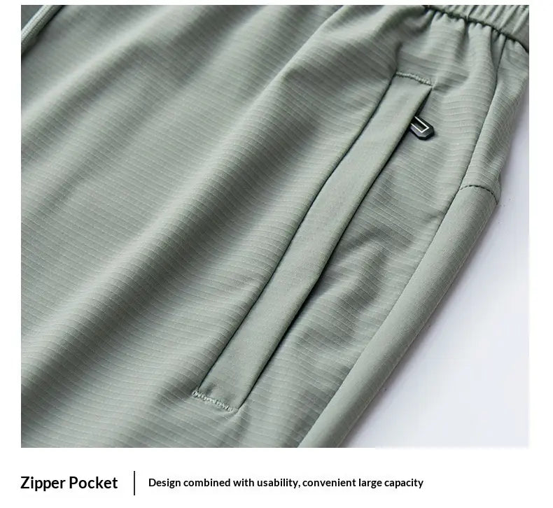 Light green ice silk antibacterial casual sweatpants featuring textured fabric and a zipper pocket with a sleek metallic pull tab.