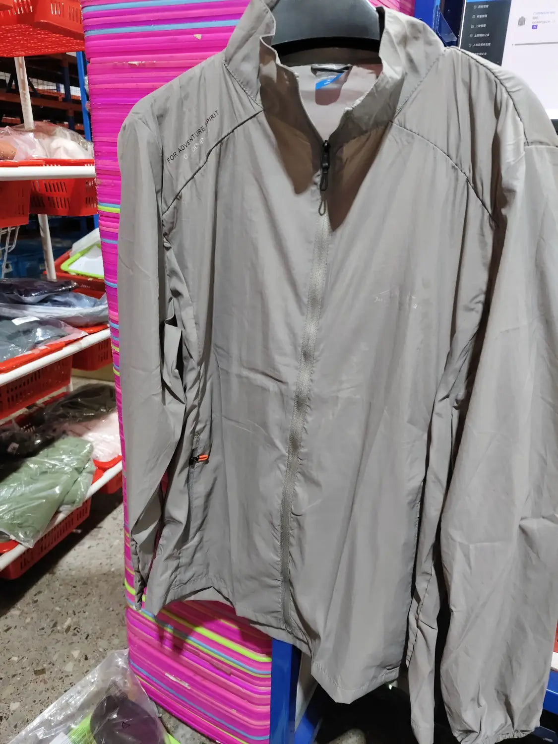 Men’s ultrathin sun protective sports jacket in gray lightweight material with a subtle sheen, high collar, and zippered front.