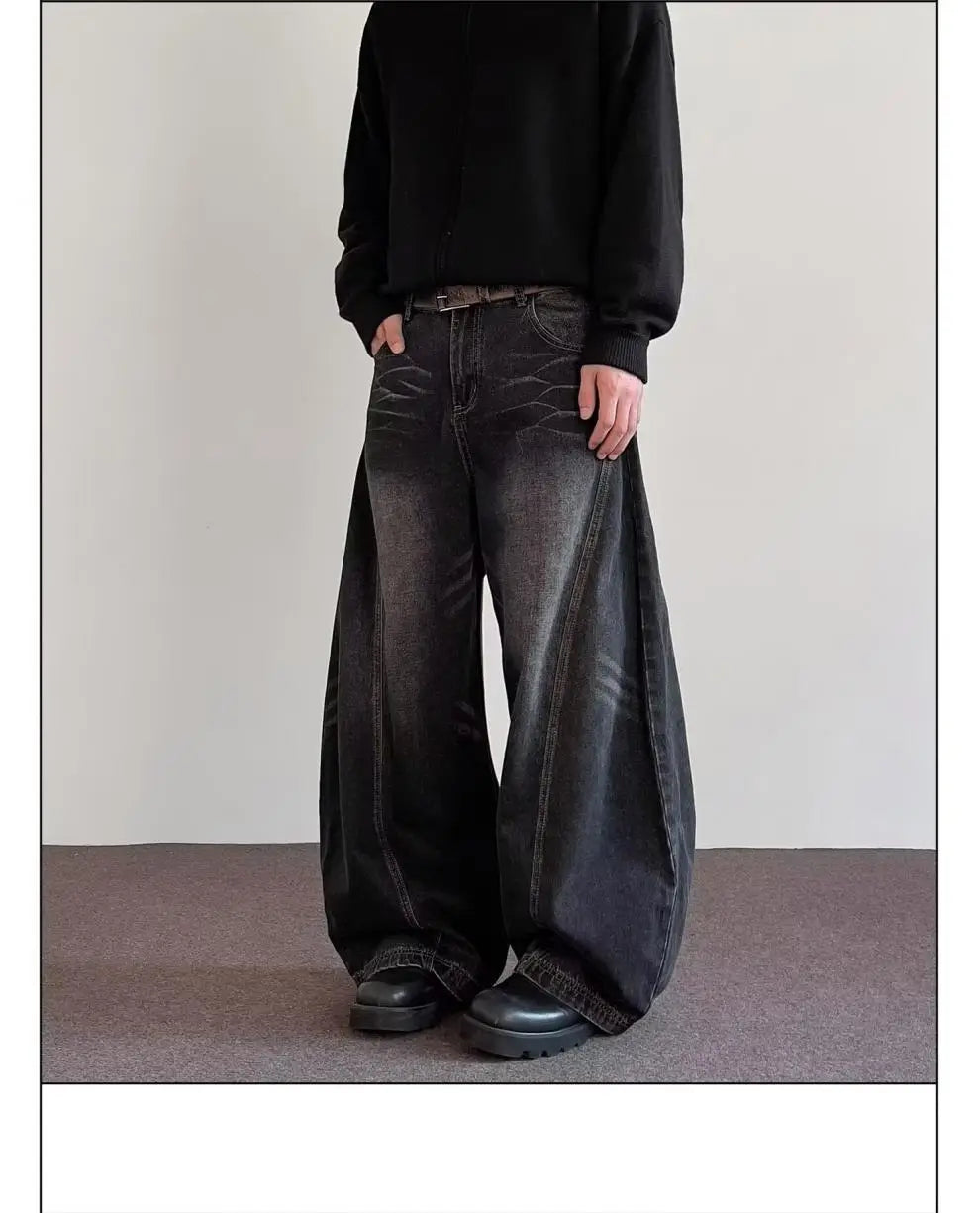 men’s premium relaxed wide leg denim jeans in black with a faded distressed texture and visible stitching details.