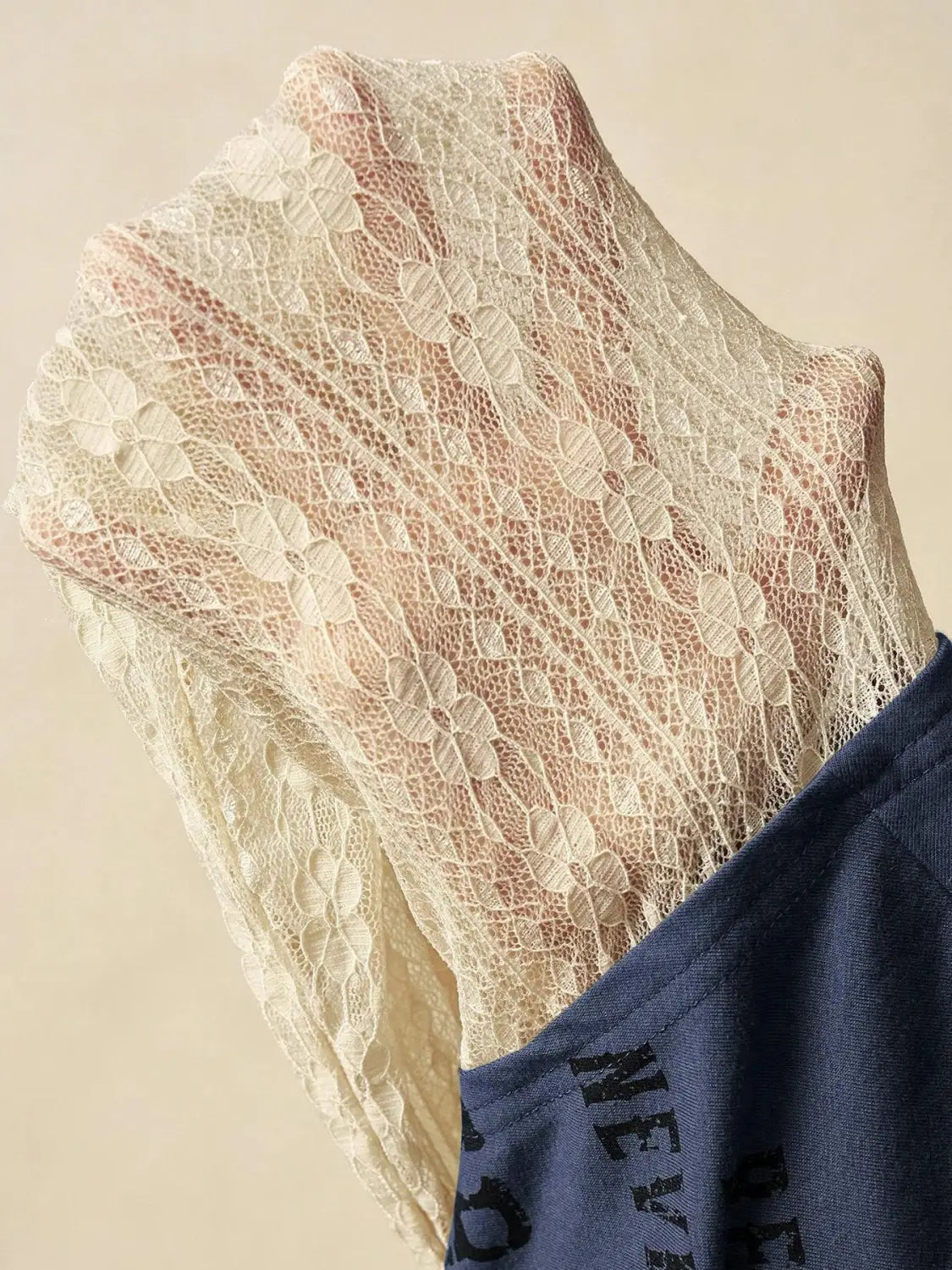 A delicate off-white lace layer off shoulder knitted top featuring intricate floral leaf and petal patterns.