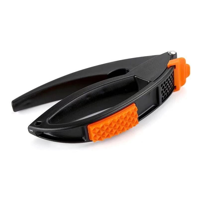 black and orange plastic nutcracker with textured grip pads from a garlic press and vegetable peeler kitchen tool set.