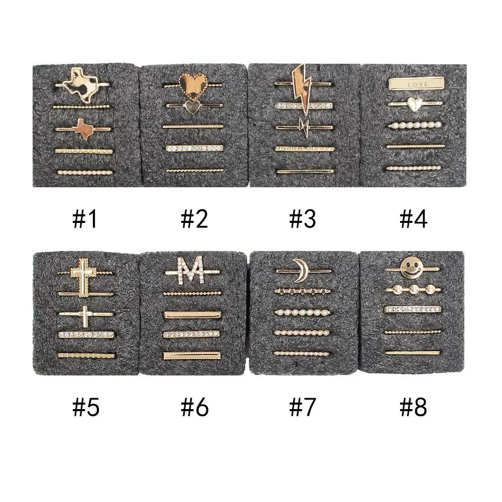 Gold and silver metal hairpins with gold embellishments and decorative charms including a Texas outline heart lightning bolt and smiley face from the gold embellished silicone strap decorative ring set.