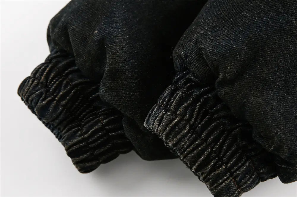 男性用ダメージ加工デニムフード付きウィンタージャケットに合わせた、伸縮性のあるカフス付きブラックデニムパンツ。