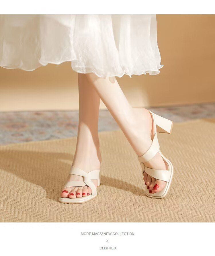 Cream-colored leather chunky heel open toe sandals with a crisscross strap design.