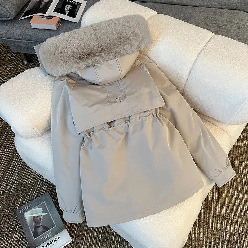 Parka matelassée à capuche avec col de fourrure beige, capuche doublée de fourrure gris clair duveteuse et taille élastique.