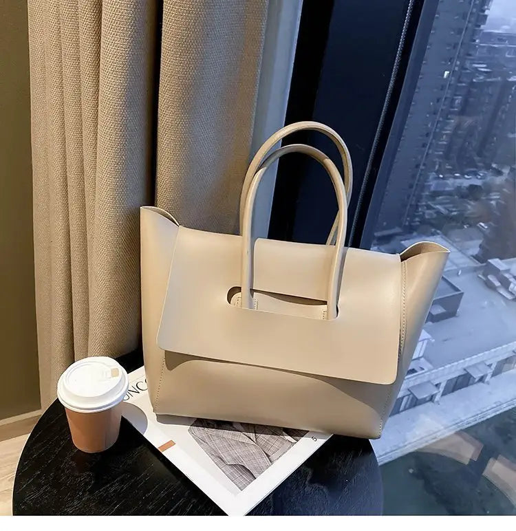 Beige leather vintage structured tote bag with top handles and a rigid silhouette.