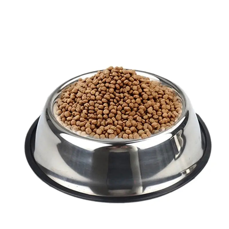 Shiny stainless steel pet food bowl with a black non slip rubber base filled with brown kibble.