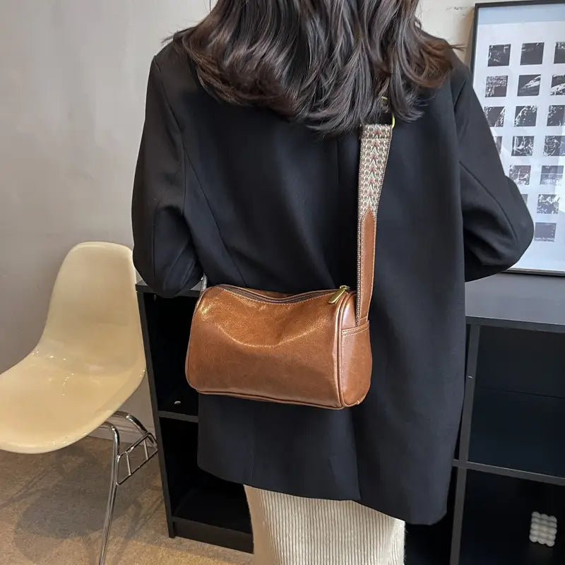 Brown leather retro crossbody bag with a patterned strap and gold-tone zipper.