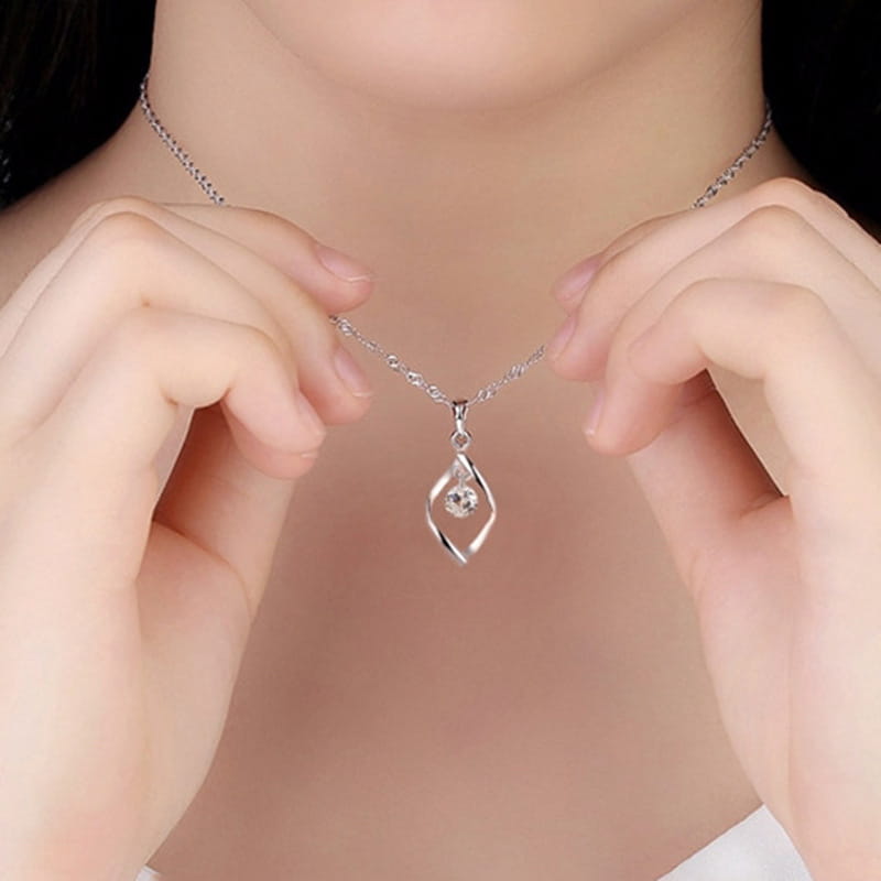 Silver necklace featuring a delicate chain and an elegant twisted diamond-shaped pendant with a central clear zircon gemstone.