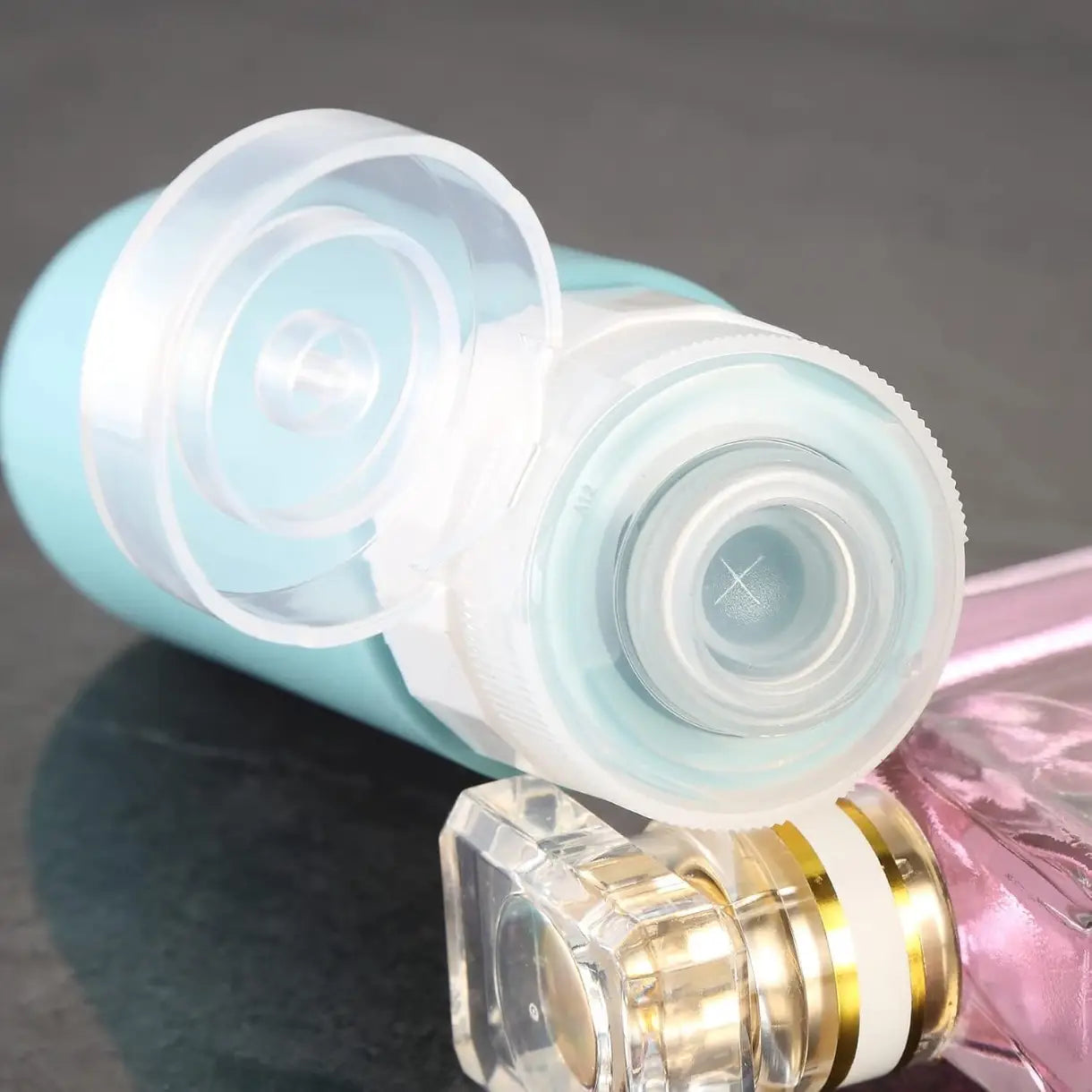 bouteille de voyage en silicone réutilisable translucide bleu clair, avec un bouchon transparent à clapet et un joint interne, provenant de l’ensemble anti-fuite.