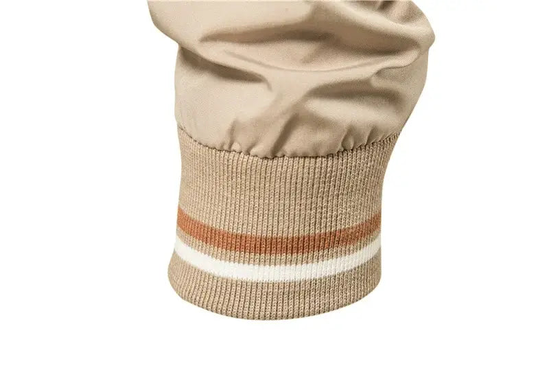 Beige knit cuff with ribbed texture and rust orange and white horizontal stripes on men’s bomber jacket casual zip outerwear.