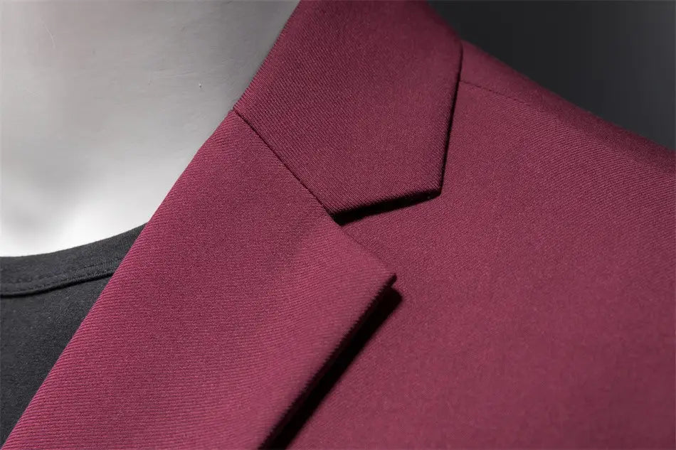 La chaqueta de vestir empresarial de pana granate con ajuste slim presenta un cuello estructurado y una tela suave a medida con textura sutil.
