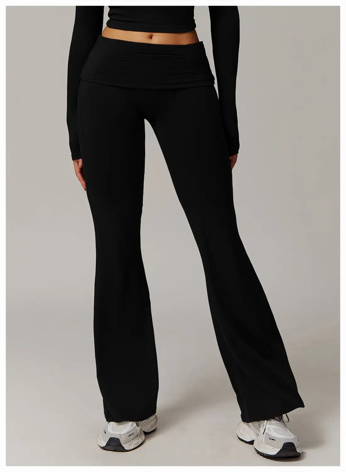 pantalones de yoga acampanados de cintura alta en negro hechos de tejido liso elástico que ofrecen un ajuste cómodo.
