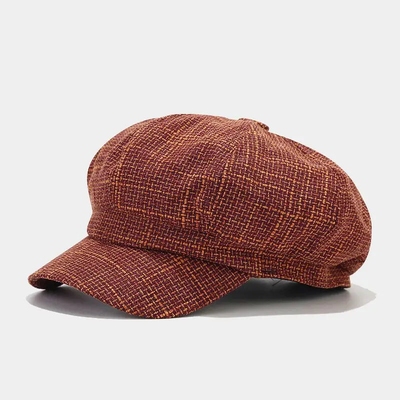 British style tweed octagonal cap for women featuring a textured rust-colored flat cap with a subtle plaid pattern and a structured brim.