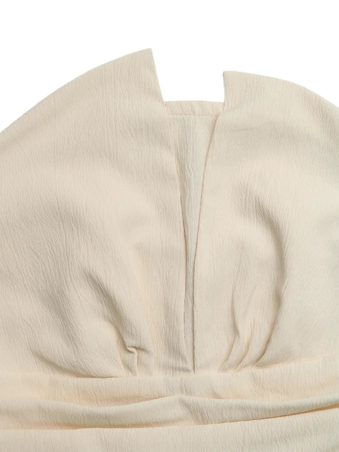 Cream strapless pleated jumpsuit featuring cream-colored softly textured fabric with a subtle sheen and gentle pleats along the center seam.