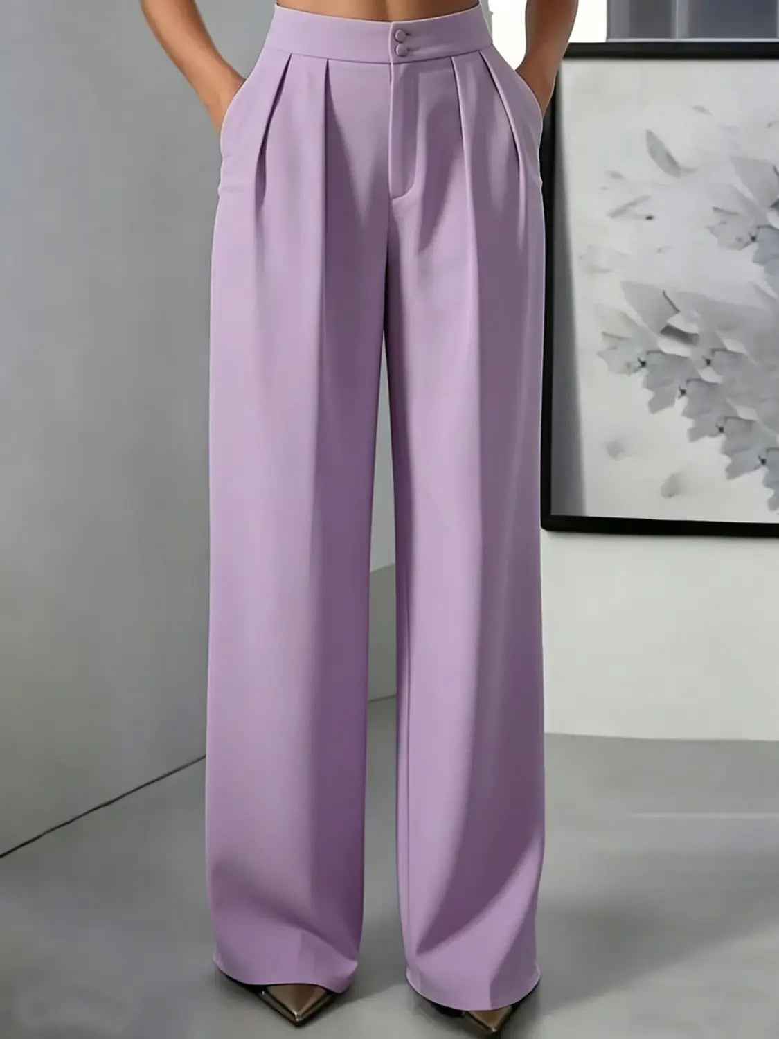 Pantalons plissés à jambes larges et taille haute en lilas avec des boutons à l’avant, conçus pour une tenue stylée et confortable.