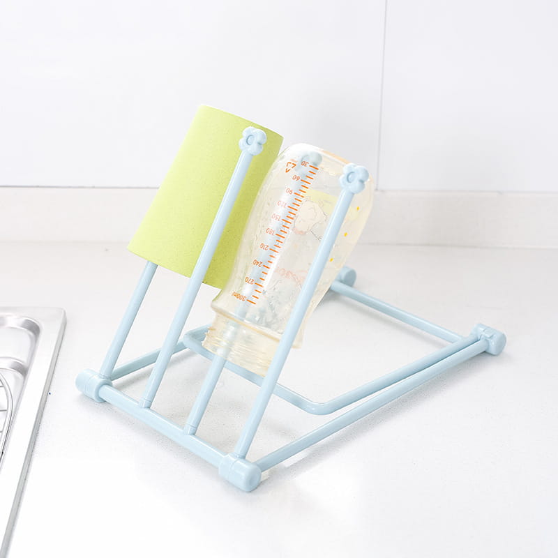 Light blue plastic foldable dishcloth rack kitchen towel organizer shelf with lime green foam insert holding a clear measuring bottle.