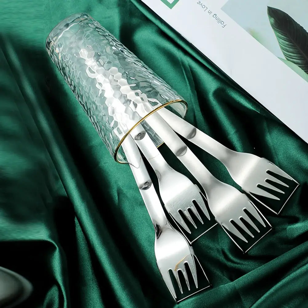 ensemble de quatre fourchettes-slicers à pastèque en acier inoxydable poli au design moderne, présentées dans un verre transparent martelé avec une bordure dorée.