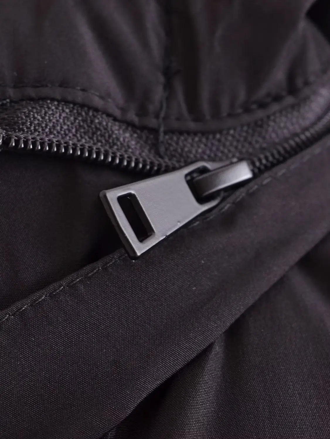 black quilted hooded puffer coat featuring a black nylon zipper with a matte silver metal pull tab