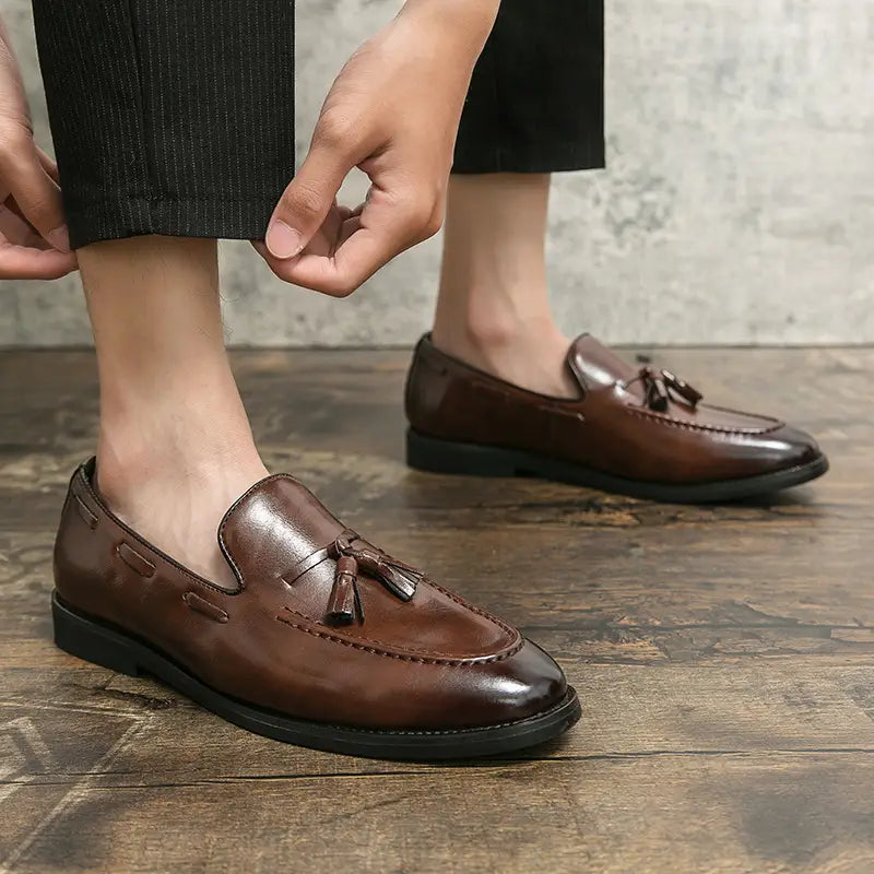 Brown leather tassel loafers with a polished finish and black rubber soles slip-on shoes.