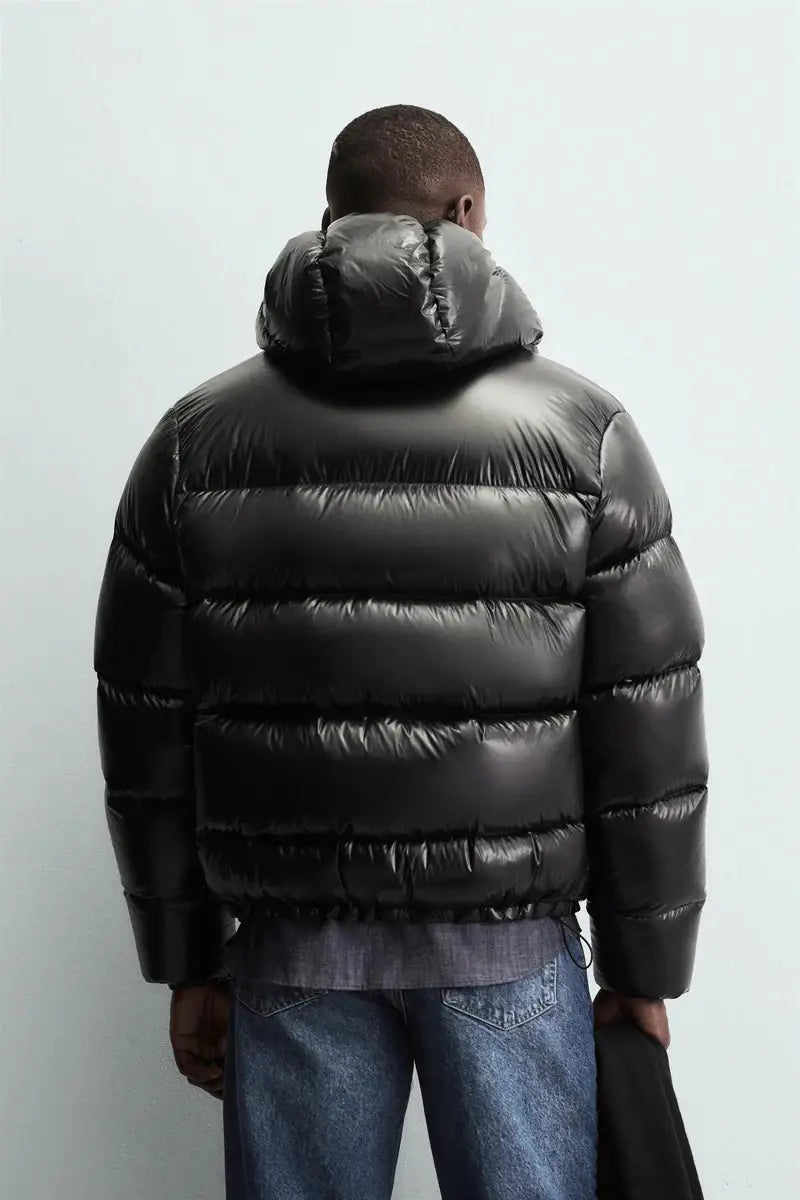 Schwarze glänzende wattierte Kapuzen-Steppjacke mit waagerechter Steppnaht, von der Rückseite sichtbar