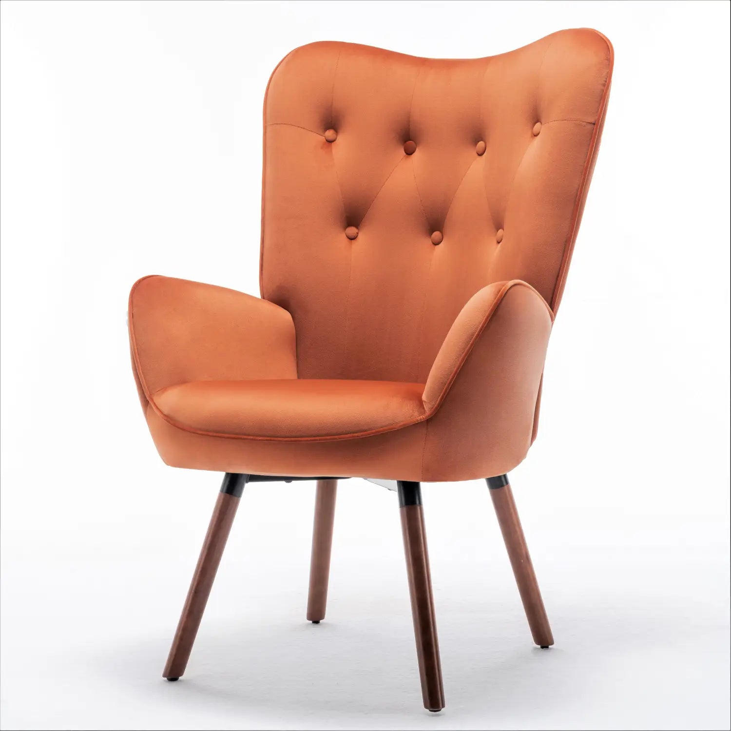 Una acogedora silla de acento tipo wingback de estilo moderno de mediados de siglo en terciopelo naranja, con respaldo acolchado y patas de madera.