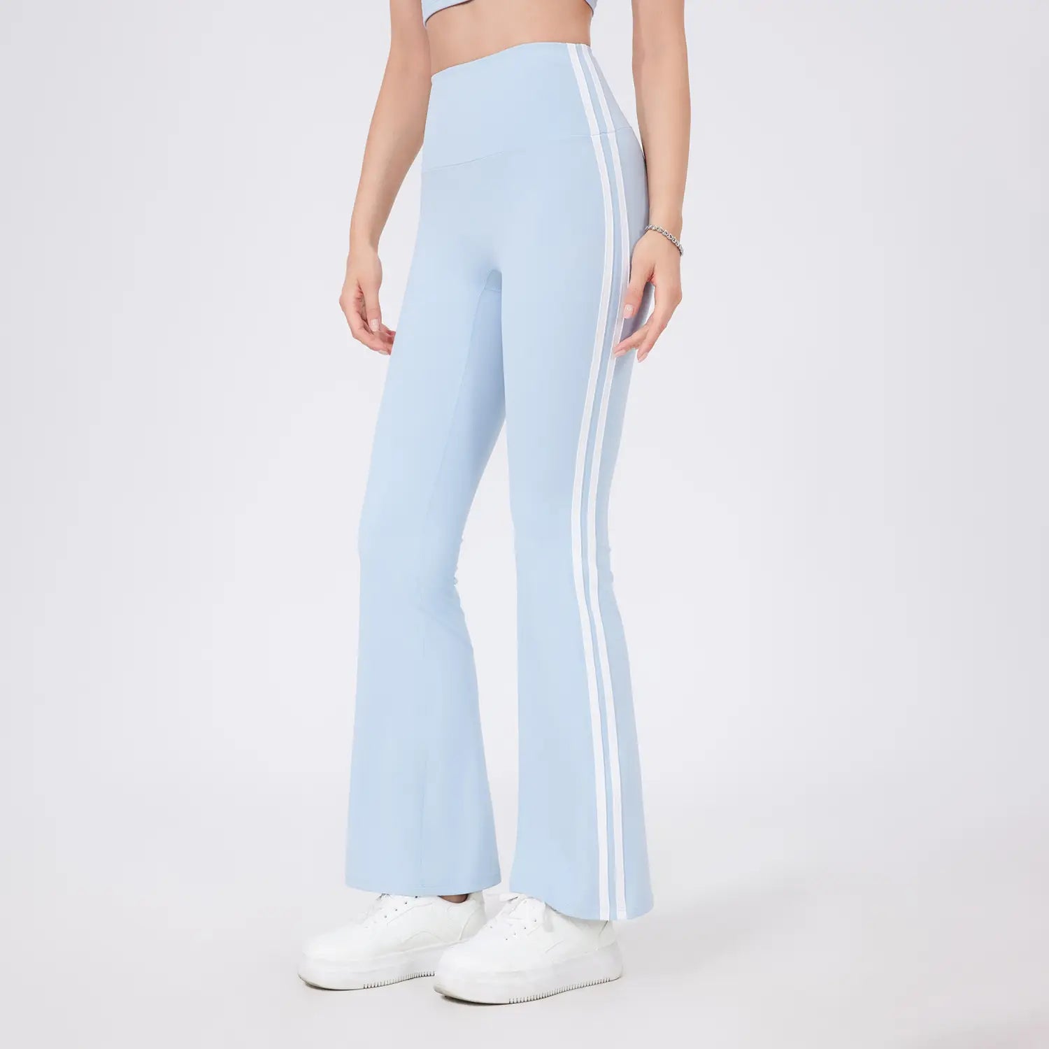 Leggings de yoga évasés taille haute bleu clair, présentant deux bandes latérales verticales blanches sur chaque jambe, conçus pour le confort et le style pendant les entraînements.