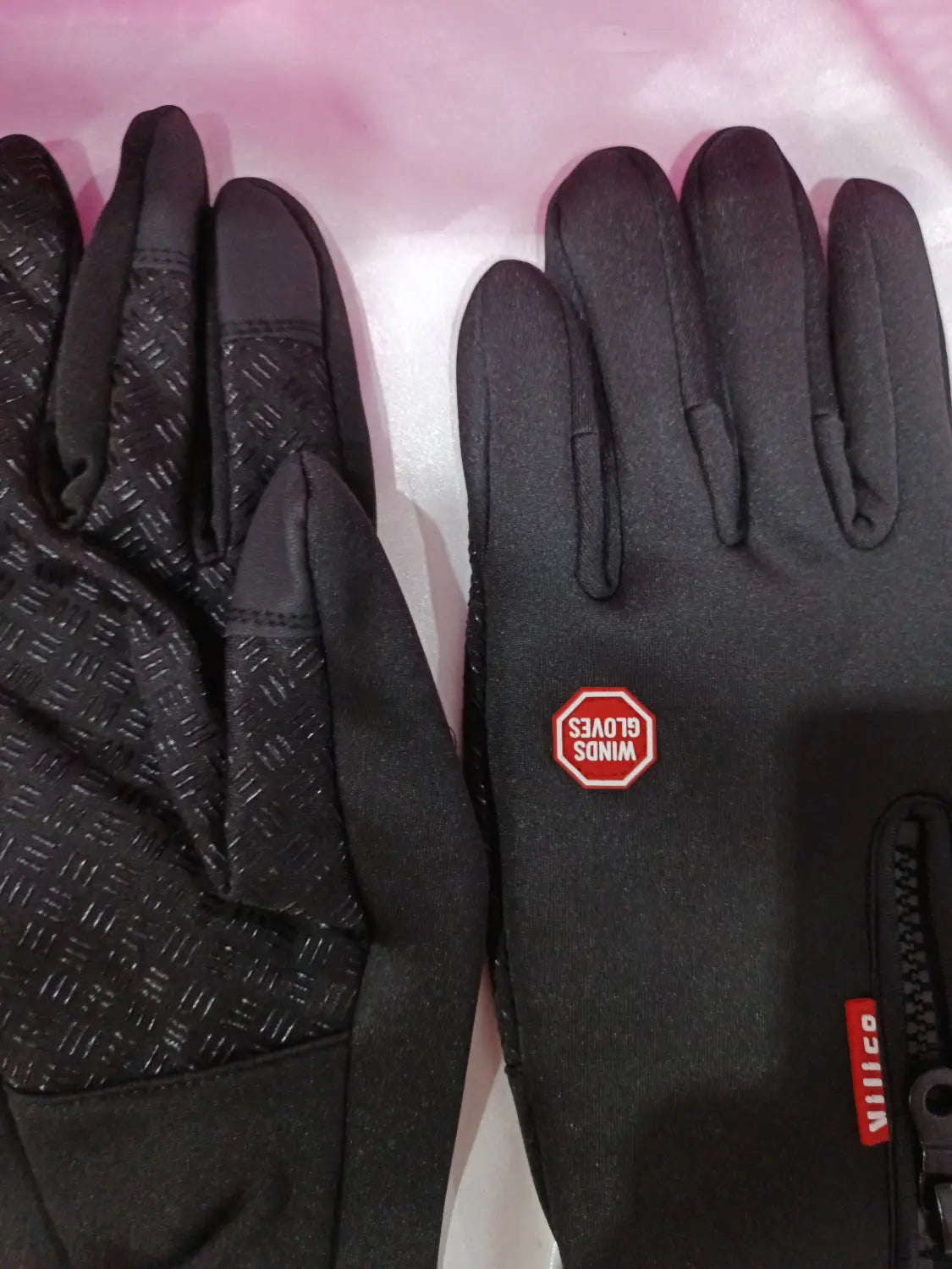 Black windproof touchscreen winter gloves for men and women with a subtle textured palm pattern and red branding patches shown from the back side.