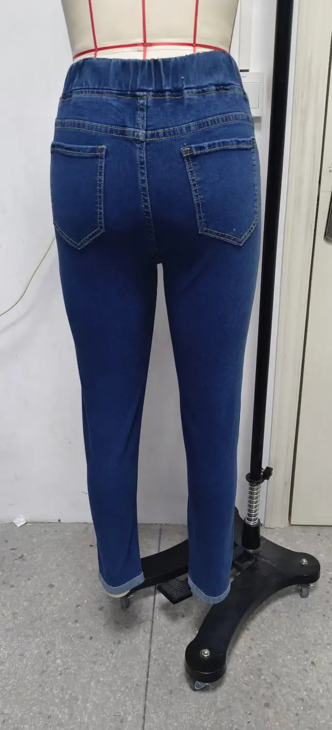 High waist slim denim leggings in blue denim with a high-waisted elasticated waistband and rolled cuffs.
