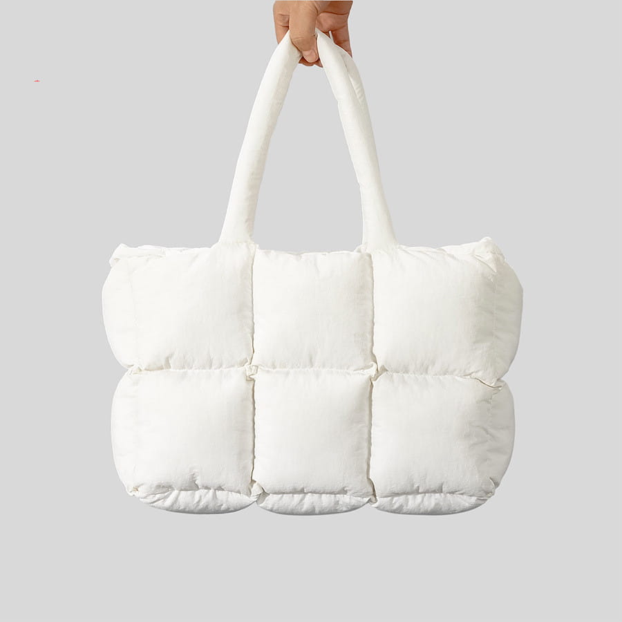 Bolsa tote acolchada tipo puffer blanca con paneles acolchados mullidos y asas de algodón suave, para un transporte cómodo.