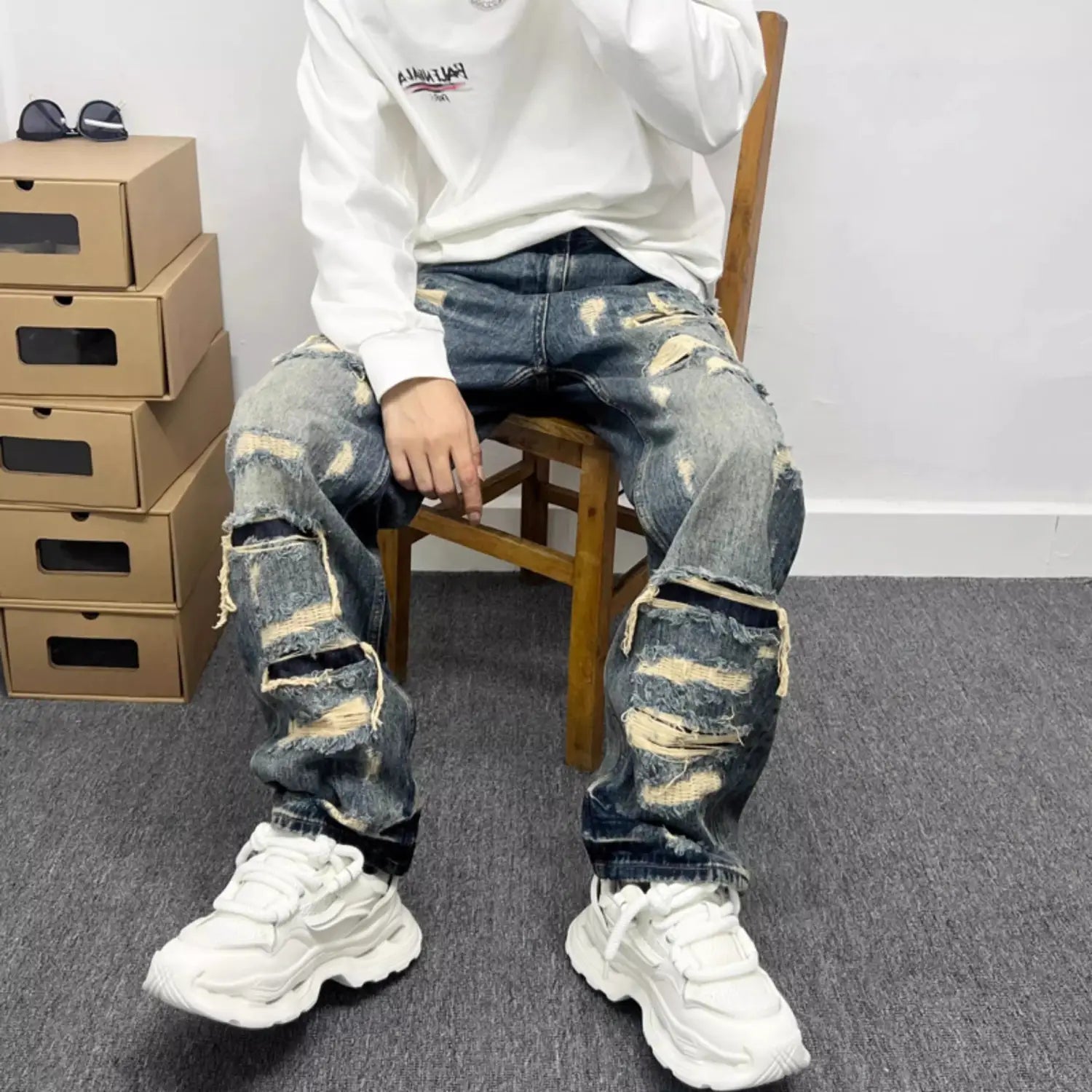 men’s light blue distressed ripped patch denim jeans featuring ripped knees and faded patches on blue denim fabric