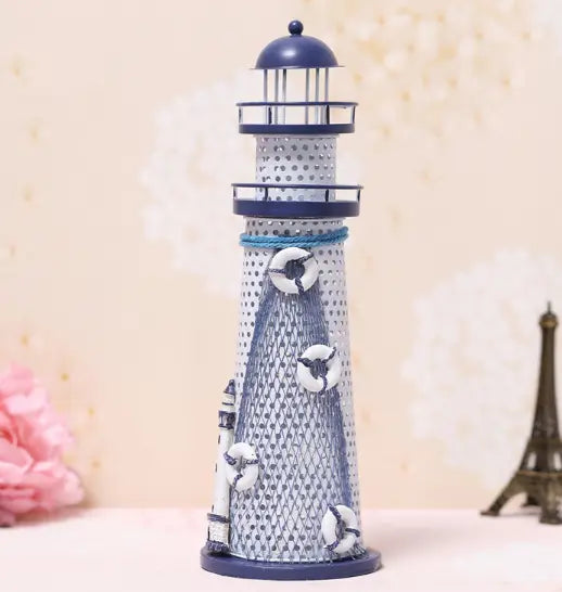 Mediterranean lighthouse garden statue decor featuring a nautical-themed metal lighthouse figurine with a navy blue dome and base and white lifebuoys on its textured gray body.