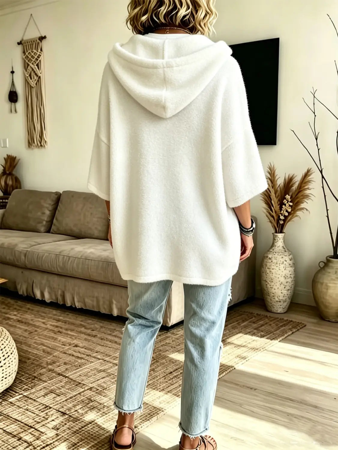 white oversized fleece hooded top with soft texture and three-quarter sleeves displayed from the front