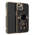 Black astronaut-themed electroplated phone case with gold trim and 3D standing figure on the back side