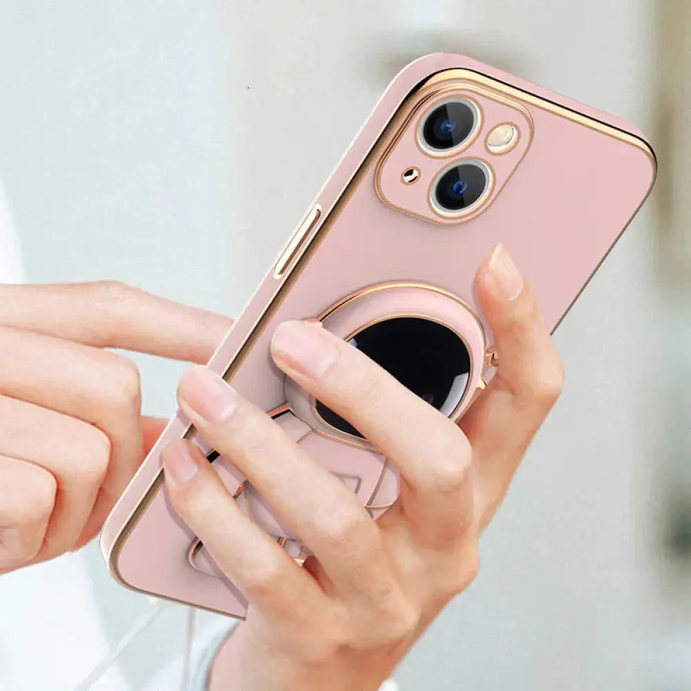 Back side of a pink 3d astronaut electroplated anti-drop phone case with gold trim and built-in circular grip ring