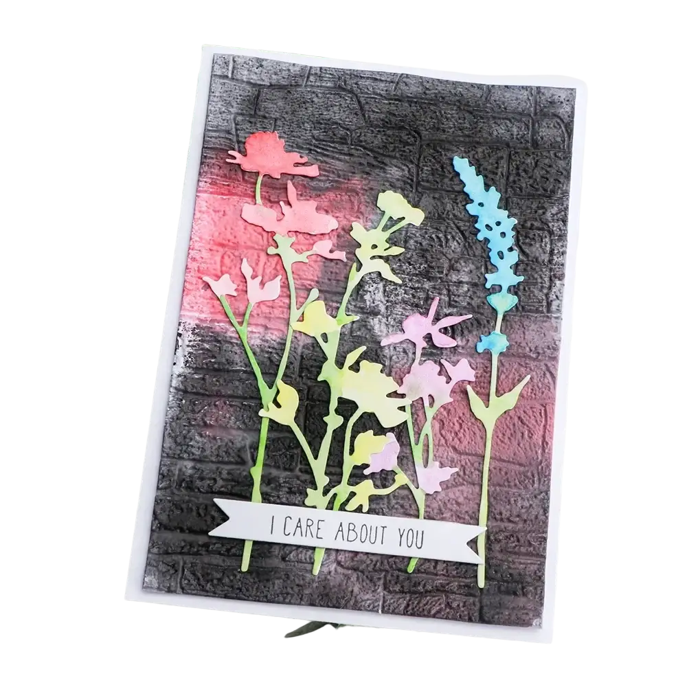 A handmade greeting card with 3d floral embossing folder featuring pink yellow and blue layered paper flowers and care banner