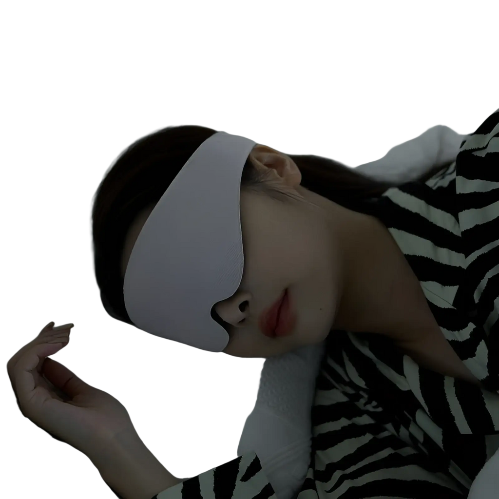 A person lying in bed wearing a white breathable 3d contoured fabric sleep mask for eye shading cover
