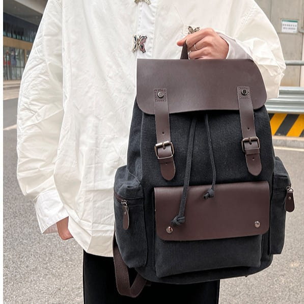 Dark gray canvas retro backpack with brown leather accents and metal buckles featuring large capacity and wear resistant material.