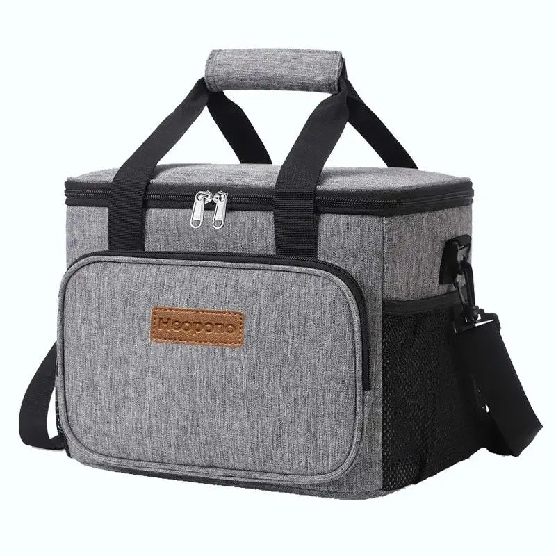 Gray heathered fabric insulated cooler bag with black straps and a brown leather-like brand patch designed as a large portable crossbody lunch case.