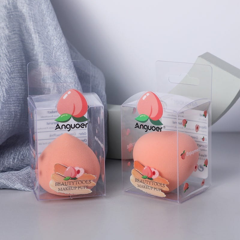 Peach-shaped soft pink silicone makeup puff in clear plastic packaging with a branded label from the makeup sponge set hydrophilic beauty blender kit.