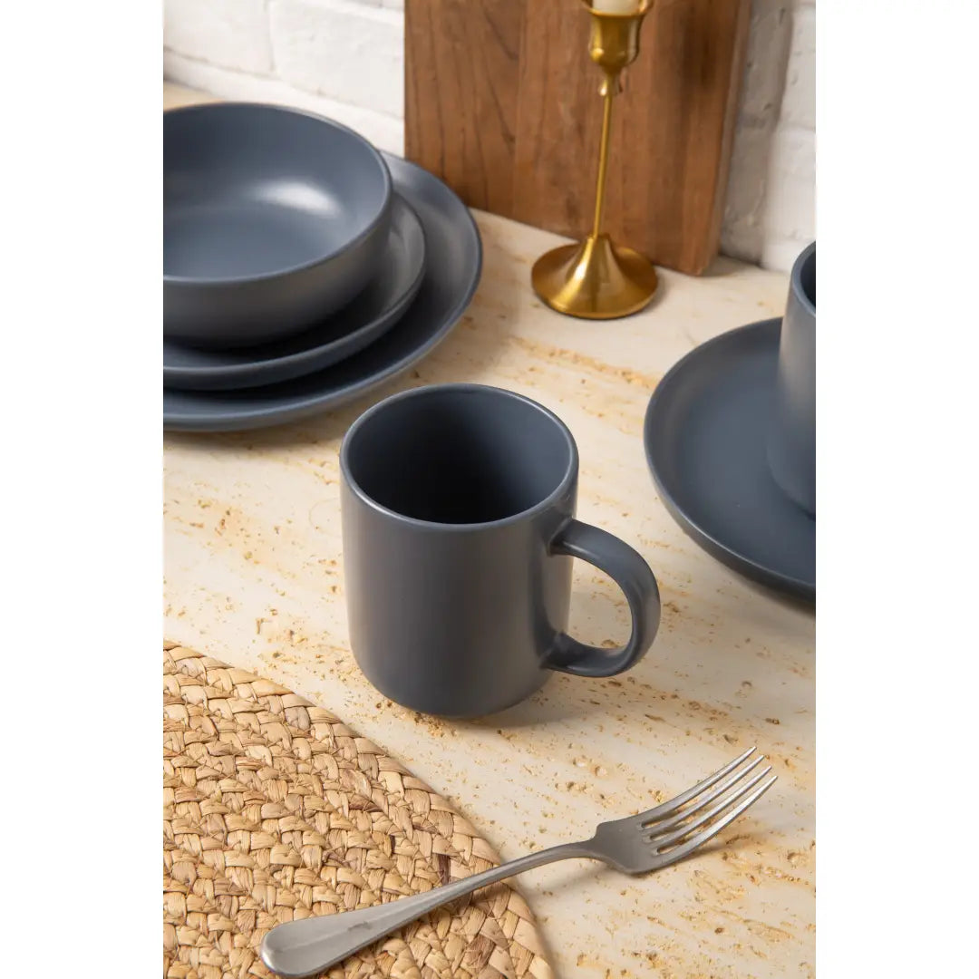 A matte gray ceramic mug with a simple modern design and matching handle from the 12-piece stoneware dinnerware set matte glaze service for 3.
