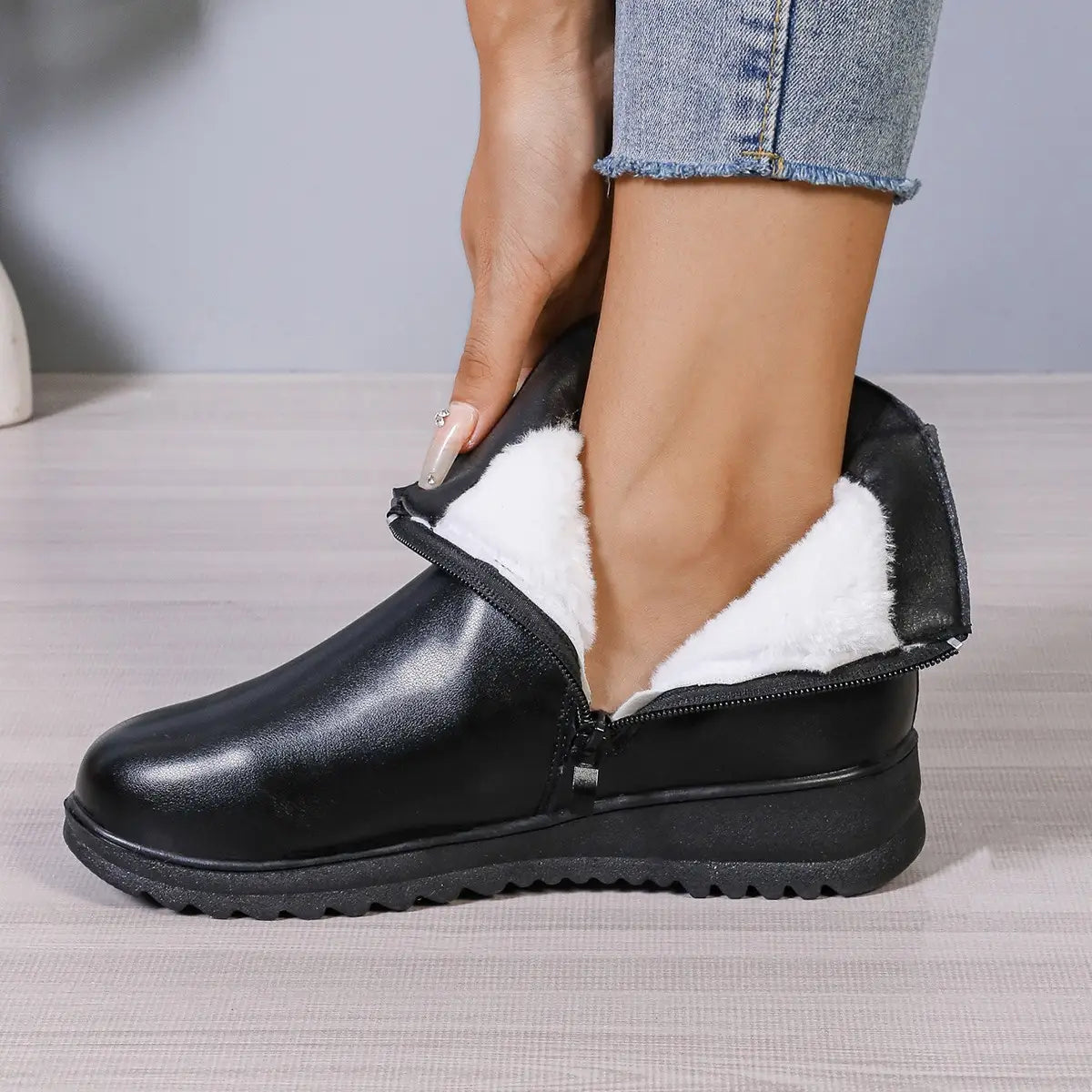 Schwarze Damen-Winter-Fleece-Ankle-Boots aus Leder mit weißem Kunstfellfutter und seitlichem Reißverschluss für das Tragen bei kaltem Wetter.