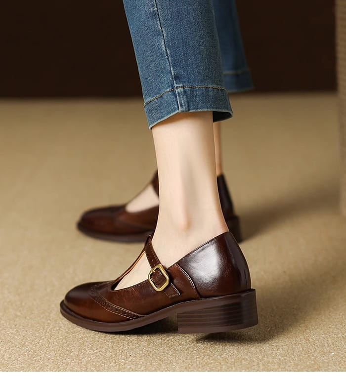 Braune Leder-Brogue-Mary-Jane-Pumps mit klobigem Absatz mit goldfarbenem Schnallenverschluss und Blockabsatz.