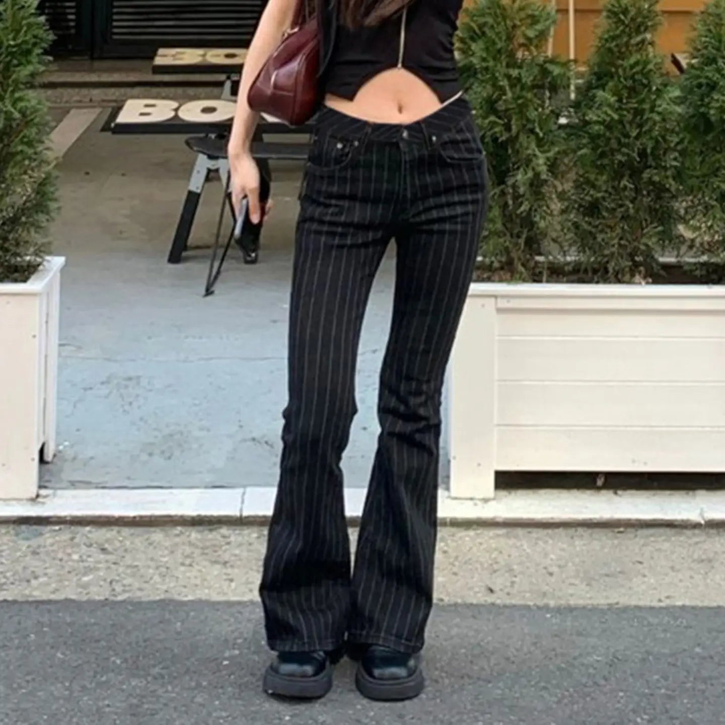 Schwarze Pinstripe-Schlagjeans mit niedrigem Bund aus Denim mit schwarzem Denim-Material, dünnen vertikalen Paspelierungen und einer Schlag-Silhouette