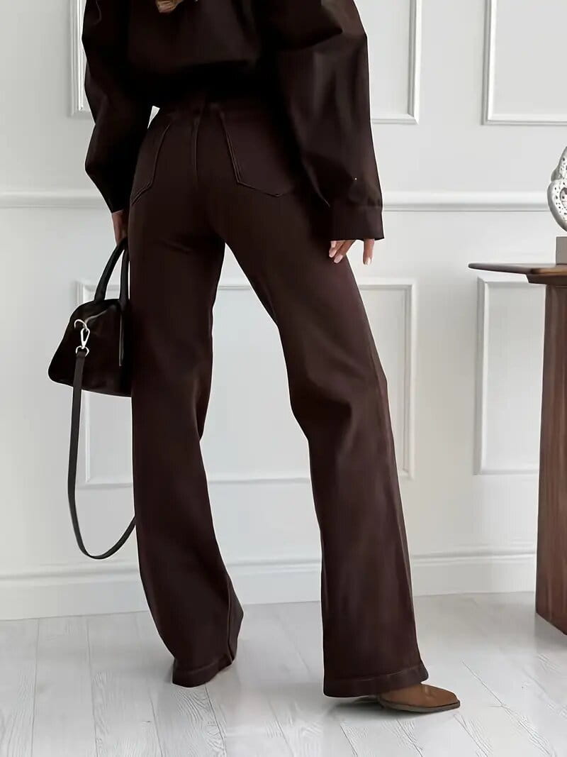 Brown high waisted flared jeans made of dark brown fabric with a sleek tailored fit shown from the front.