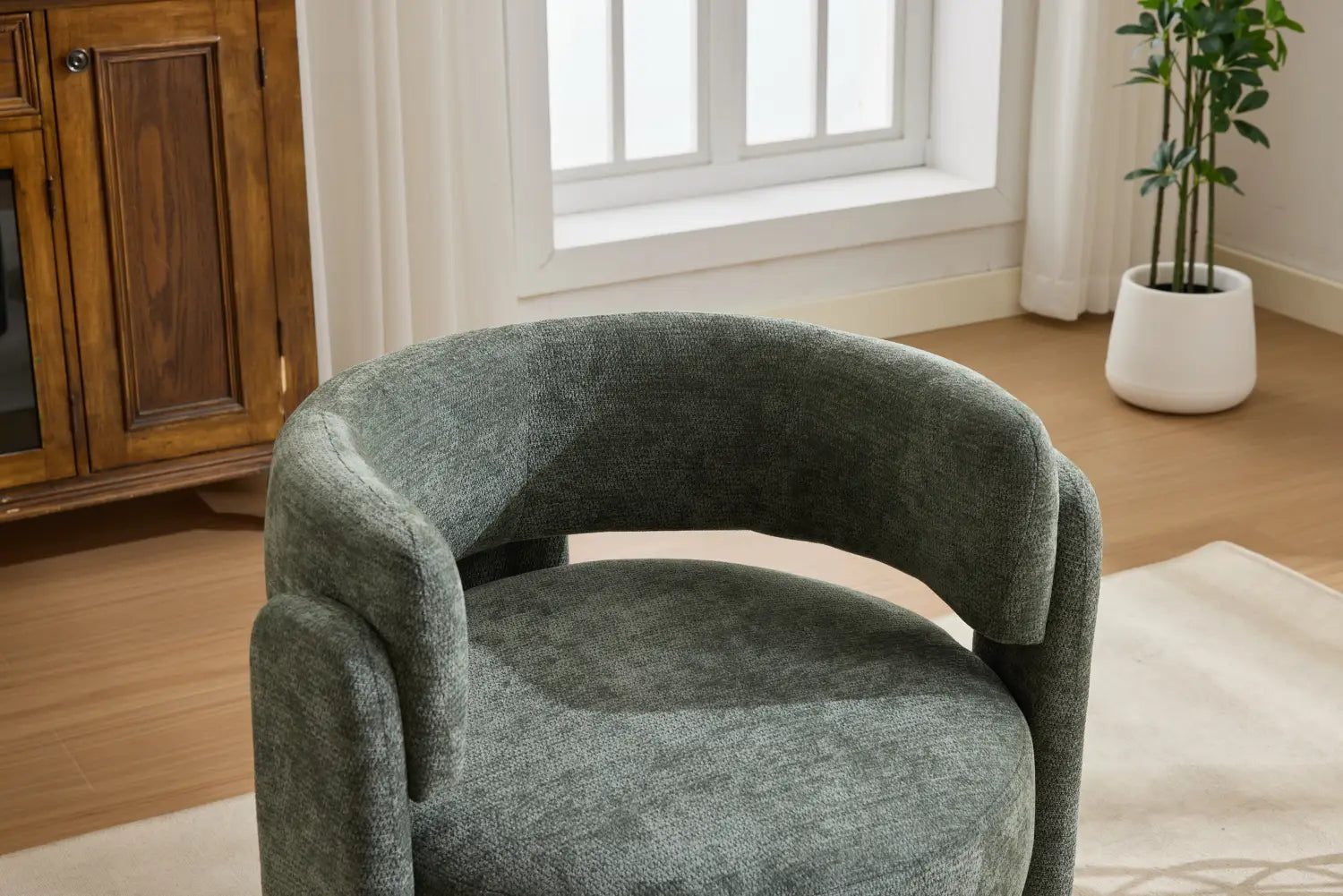 Ein moderner Bouclé-Akzentstuhl aus einem Salbeigrün-Stoff mit einer behaglich gerundeten Form und strukturiertem Bezug.